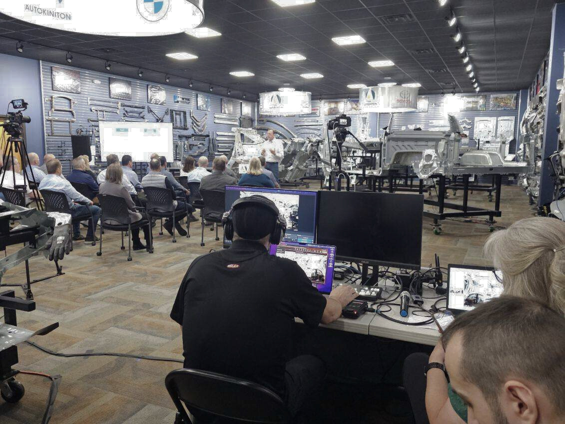Live event production team streaming a corporate presentation inside a high-tech automotive display center
